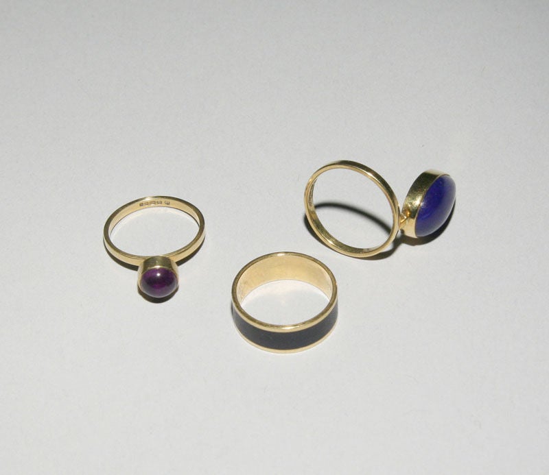 Using an acrylic chess piece as a holder for her set of rings, Wendy Ramshaw designed this triple ring set in 18 karat gold and included a pear shaped lapis ring, a bezel set cabochon amethyst ring and a blue enamel band.  The rings can be worn