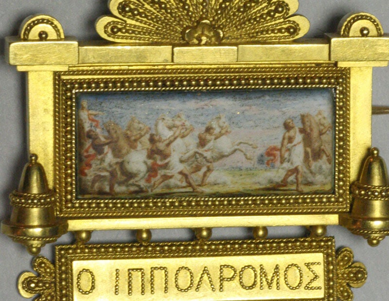 This brooch of an equestrian race is by Eugene Fontenay (1824-1887) who is considered one of the master jewelers of the 19th century.  Fontenay was famous for his work in the Etruscan revival style, of which this brooch is an excellent example.  He