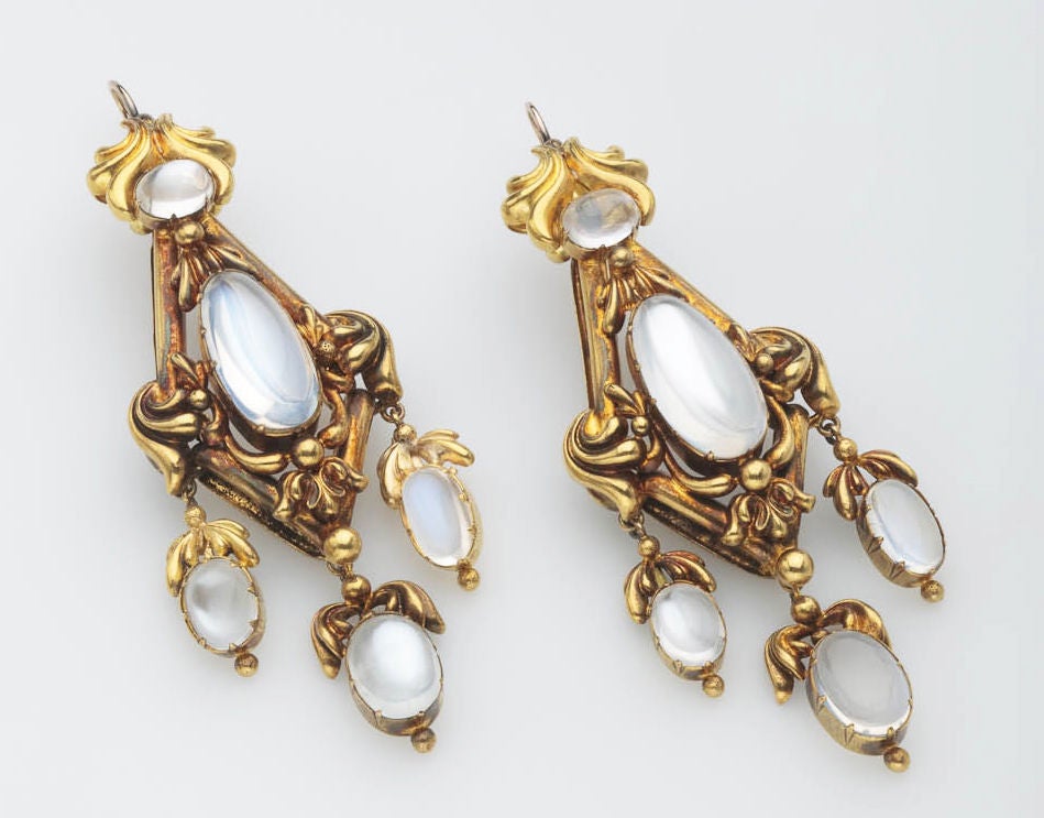 Antique earrings in 18 karat gold with blue moonstones.  Braced backs indicate the earrings are late Georgian or early Victorian.  Solder evident on back where drops are attached.  Some gold discoloration on back, Replaced wires.