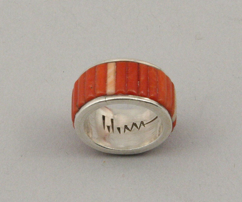 An early sterling silver ring set with bands of coral and fossilized ivory by Charles Loloma.  The ring is signed on the interior and fits a size 7 1/2.  