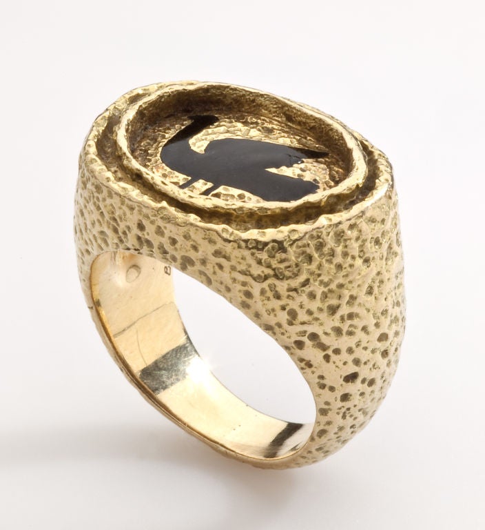 In the last years of his life, artist Georges Braque turned to designing jewelry that often evoked Greek mythology with images of birds and godesses. This ring, which is in high karat gold, shows a mythological bird set in a frame of textured gold. 