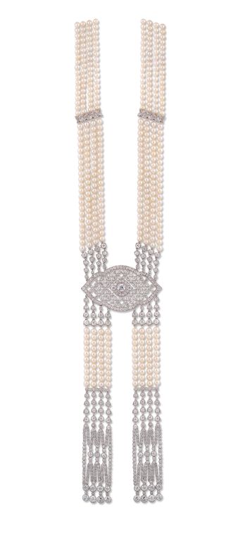 The central open-work diamond-set cartouche of stylised floral trellis design, a larger millegrain-set diamond to the centre, supporting a flexible twin ribbon pendant of diamond-set 'lilly of the valley' lines and four-strand pearl sections with