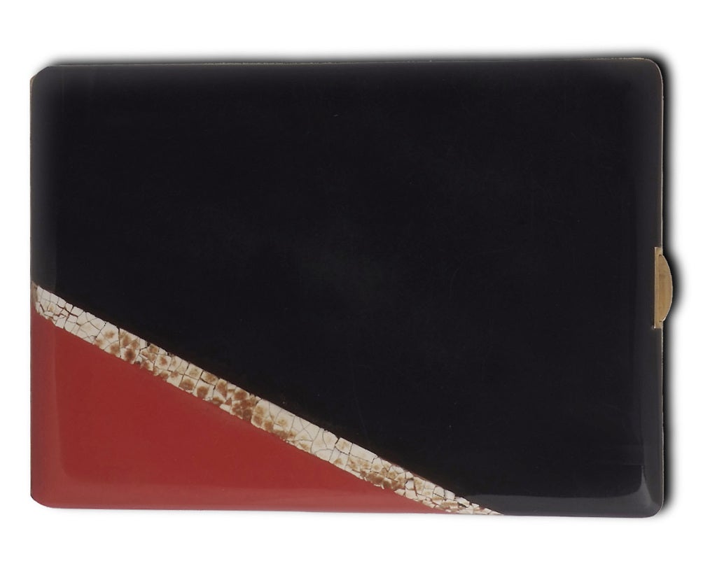 The rectangular case applied with a geometrical design in red and black lacquer and further accented with eggshell lacquer sections, circa 1929, signed Paul Brandt Paris. Cf. Laurence Mouillefarine et Evelyne Possémé, Art Deco Jewelry, Thames &