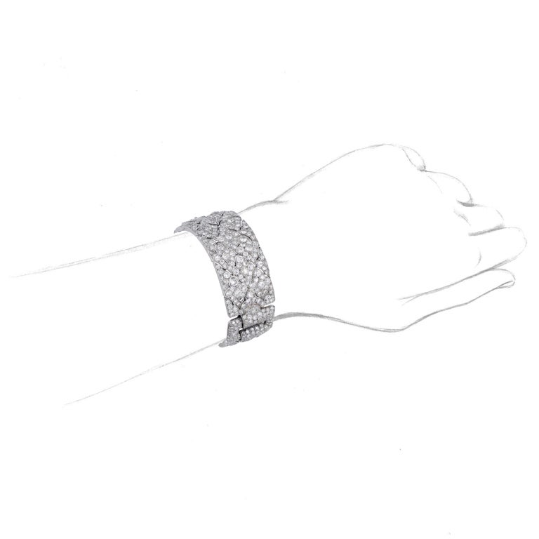Designed as two sections of stylised articulated lozenge-shaped links, connected by buckle-shaped sections, set with circular-cut diamonds, circa 1923, French assay marks for platinum, signed Cartier Paris, Londres, New York and numbered 01017.