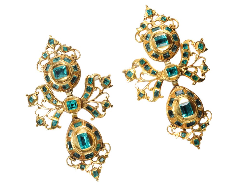 The traditional pendeloque earring consisted of a three element design – a surmount suspending a ribbon bow which supports an elongated drop similar in shape to the surmount. A number of variations on this theme existed in addition to a distinctive