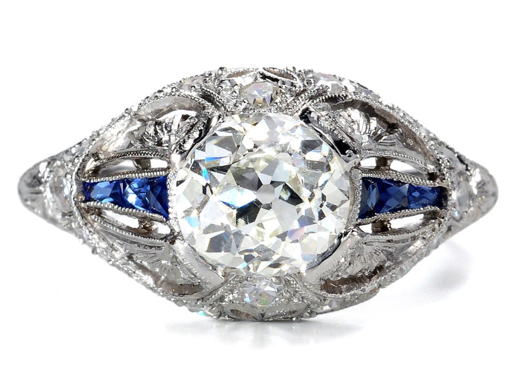 Beauty beyond beauty reaches high towards the heavens...this Art Deco ring is by far one of the most stellar engagement rings which The Three Graces has had the pleasure to offer.<br />
<br />
A spectacular cushion (old mine) cut diamond of an