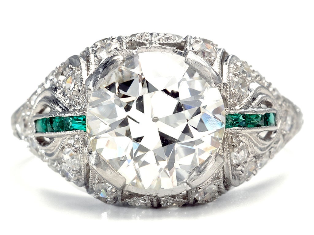 An old European cut diamond of an estimated 2.53 carats (J-K color; VS2 clarity) is the show stopper in an out of the ordinary ring. The diamond is set within a platinum open work mount and accented with fine mille grain detailing with sweeping