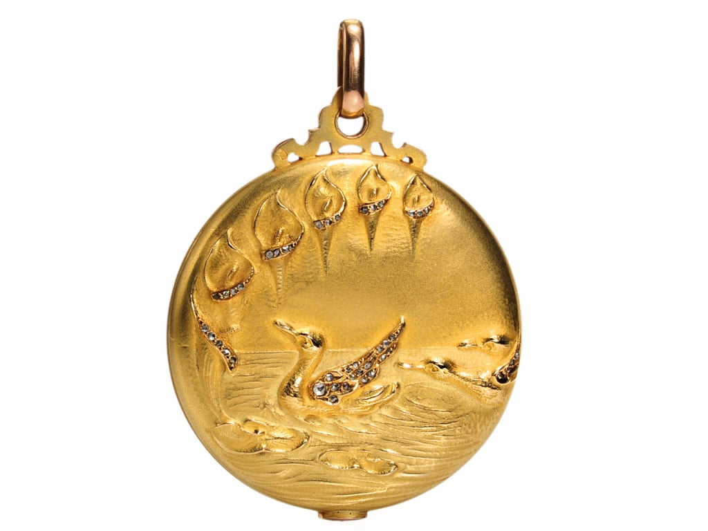 This marvelous antique 18k yellow gold locket strays from the mainstream path. Referred to as a slide locket, a mechanism at the apex enables the top to pivot and scissor open to enable the top of the piece to slide across the bottom to open. The