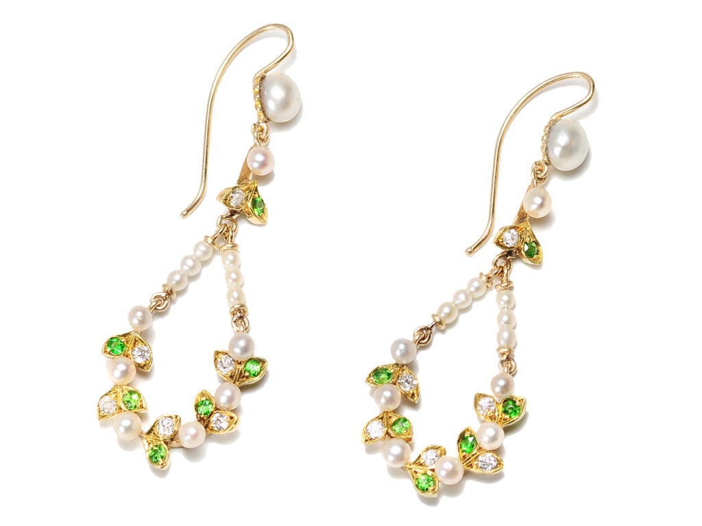 Garlands and leaf motifs set the standard for the elegant and feminine designs of the Edwardian jewelry. This pair of pendant earrings in 14k yellow gold incorporates thirty (3) superb natural fresh and saltwater pearls (untested but guaranteed to