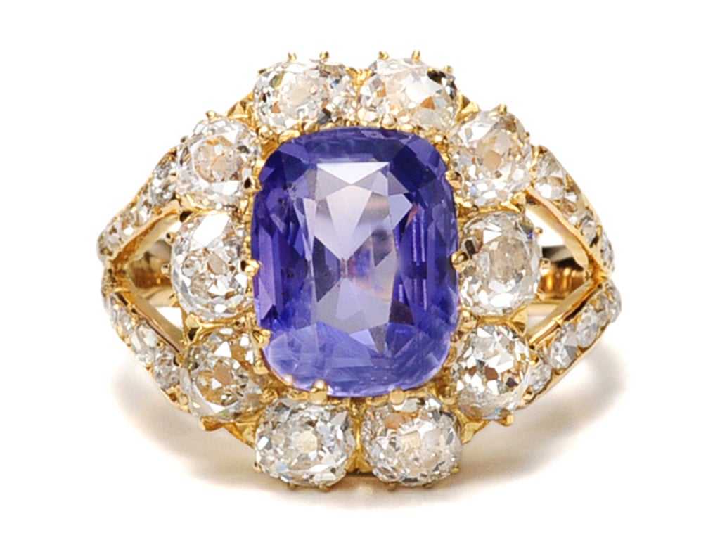 Cluster rings always make a dramatic statement whether of antique or modern origin. However, this example of a Victorian era cluster ring of 14k yellow gold is singularly spectacular. A magnificent rectangular cut natural color changing sapphire is