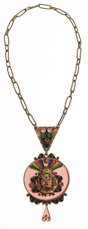 This is an entirely hand wrought copper necklace of an Aztec face with hand painting details adding local color to a piece that a tourist would take home.  It is signed with  a crown over the word Mexico. The chain is hand made of copper and brass