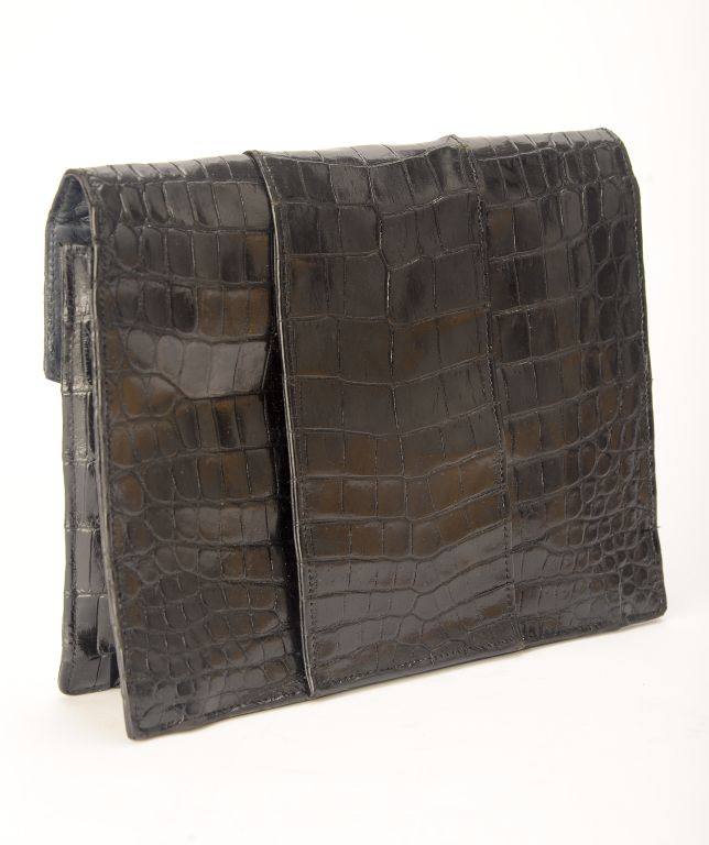 Small envelope bag in alligator with a wide tab closure and a midnight blue leather lining.
