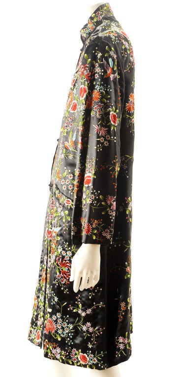This Chinese coat is all over hand embroidered in multicolored silk florals on a black satin with a full silk lining. Mandarin collar, front slant pockets, frog closures complete the look. Very fresh and happy.
