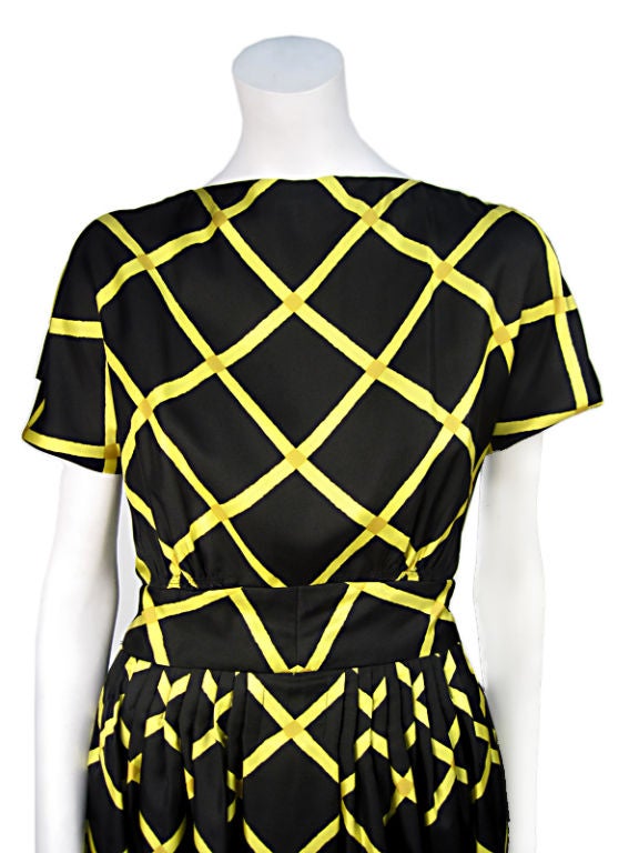 1960's silk vintage day dress from Pauline Trigere.<br />
This gorgeous black dress with beautiful yellow lattice pattern has a very elegant petite bateau neckline, short sleeves and a pleated skirt with wide waistline. What could be more