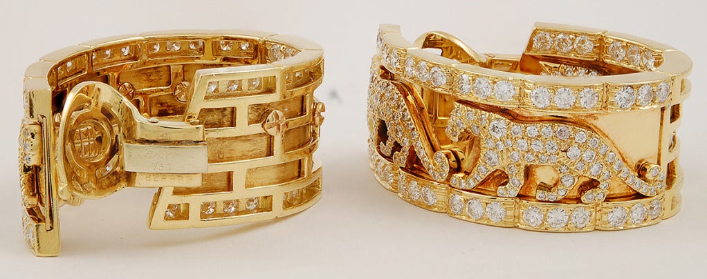A vintage pair of 1980's Cartier diamond 'Panthere' earclips; each designed as a hoop with diamond-set borders and set with three pave-set diamond panther motifs.

Signed Cartier, and numbered.