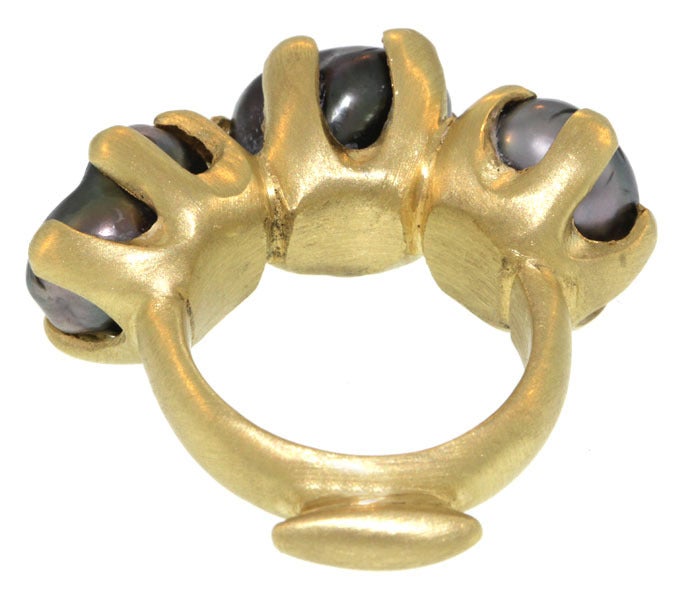 This lovely pearl ring features three lustrous grey keshi pearls in beautiful organic claw settings. The setting sets the pearls side by side, but slightly tilted away from each other, allowing them to arc elegantly over the finger. They sit on a