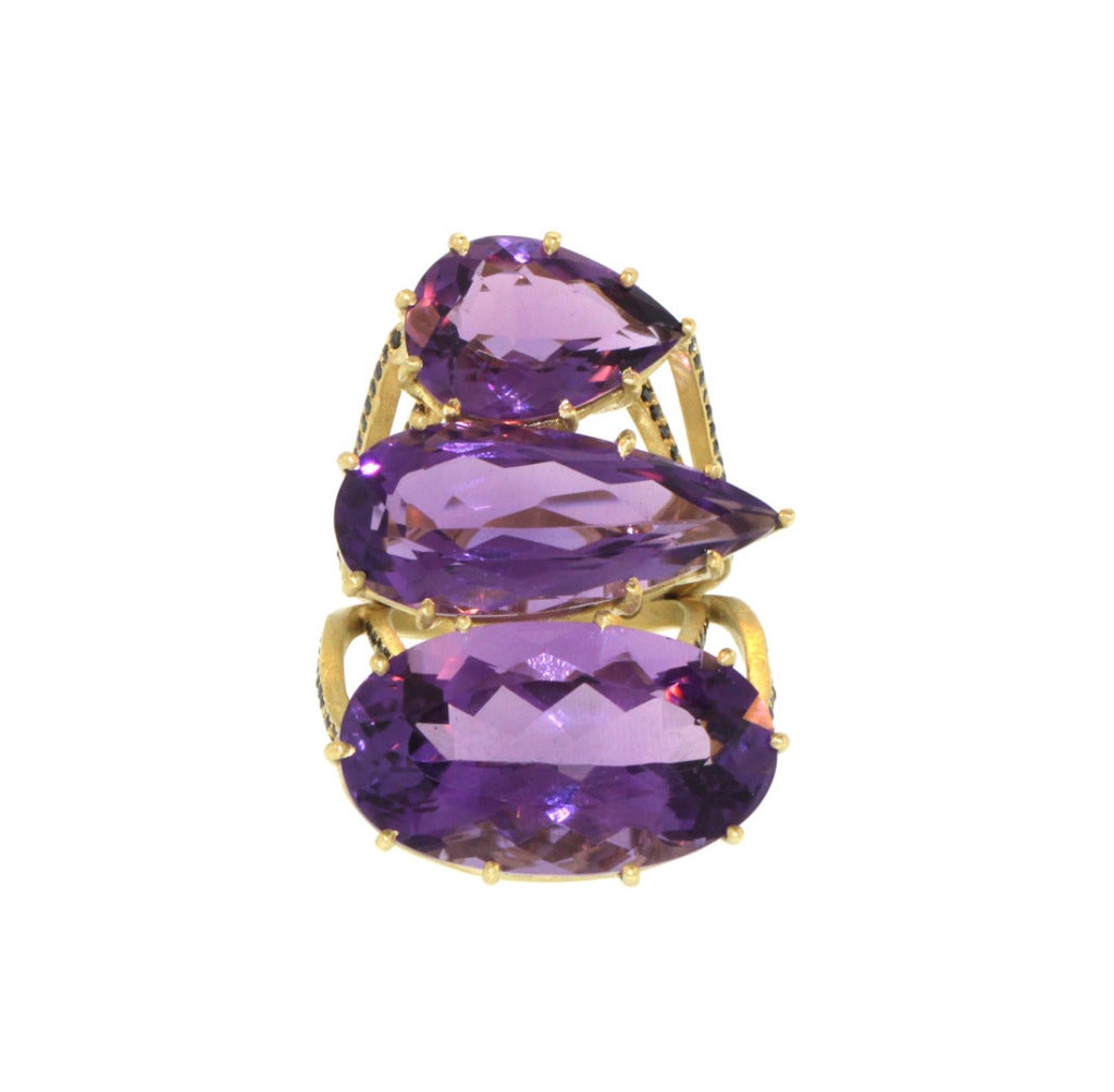Perhaps the ultimate statement ring; three brilliant cut purple amethysts weighing 43ct sit in a simple prong setting, with eight rows of rose cut black diamonds along the edges of the ring. The ring itself is made of 14.5g of 18k gold, and the