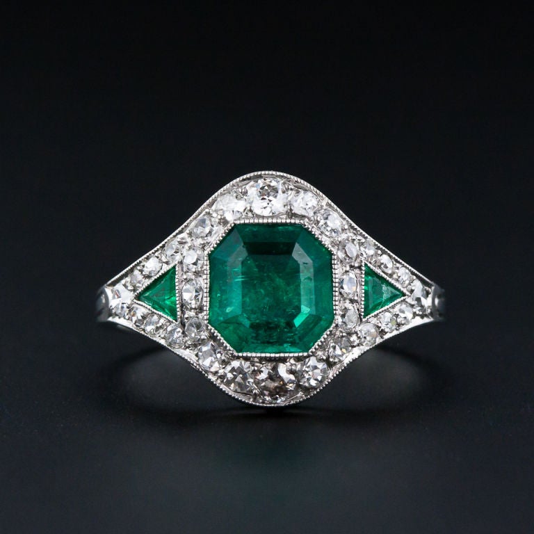 No, this is not a reproduction! It is a fabulous, rare, and all original Art Deco emerald ring from the 1920s. The deep rich green crystalline, octagonal step-cut emerald measures 1.10 cts, but appears much larger due to its slightly 'spready' cut.