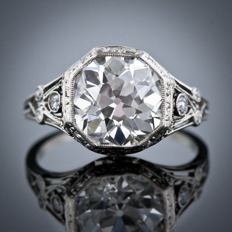 Very, very few come nicer than this sensational, all original, vintage diamond ring from the 1920s starring a blazing and beautiful European cut diamond weighing 3.55 carats. The unique and artfully restrained platinum setting combines both Art Deco