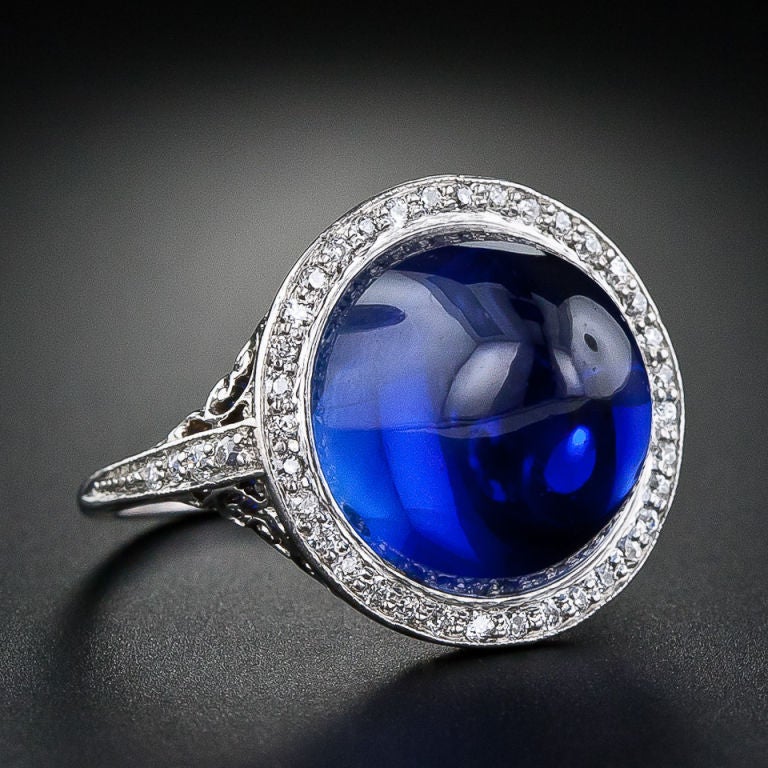 Phenomenal old gem material, transformed into a truly magnificent sugarloaf cabochon, is showcased in a sublime Edwardian mounting, circa 1900. This impressive, collectable and mesmerizing 15.75 carat natural sapphire is graced with a delicate halo