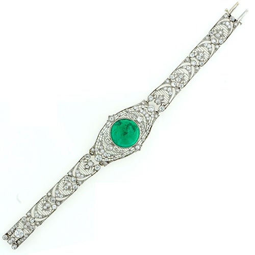 Magnificent is the word. This light and lacy Edwardian Bracelet from the beginning of the 20th century was lovingly contructed around a bright luscious green 10 carat cabochon emerald. The graceful harp like links are evocative of the overlapping