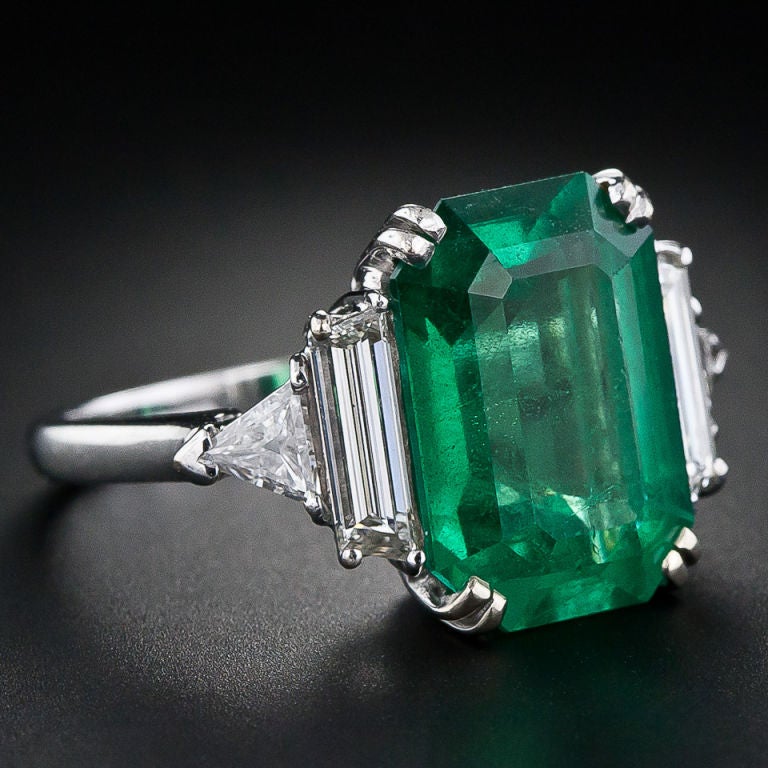 A sensational, bright vivid green 7.00 carat emerald-cut emerald exquisitely presented in a classic platinum and diamond mount. This gorgeous emerald is virtually flawless to the naked eye and, even under a 10X power loupe it is inordinately clean.