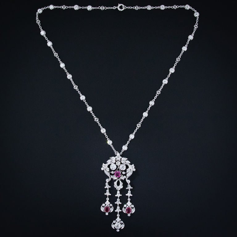 A ravishing and exemplary Edwardian Burma ruby and diamond lavaliere necklace, hand crafted in platinum, circa 1900. This rare and wonderful antique necklace has a fanciful and fluid design featuring three long pendants dangling and dancing below.