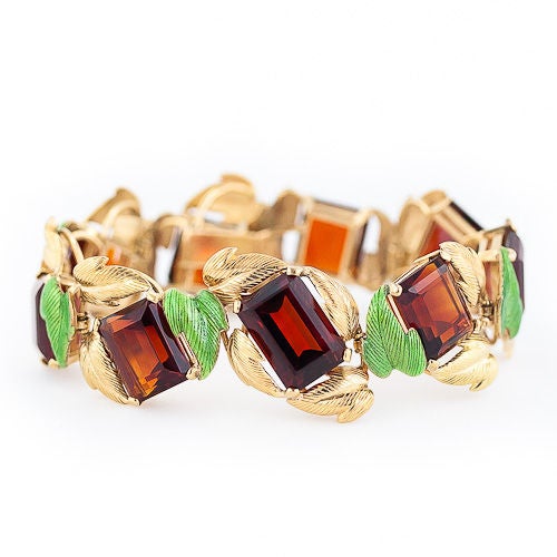 Deep amber color emerald-cut Madeira Citrines entwined in bright spring green and golden leaves add-up to an unusual and dramatic color combination in this tantalizing mid-century bracelet and earring set.

The bracelet is composed of nine