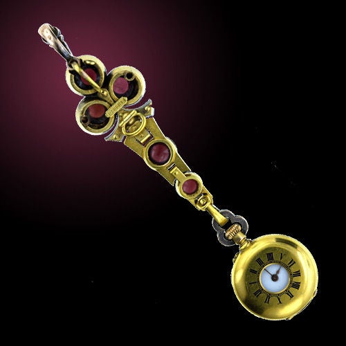 A supreme gem from 19th century Paris. Rich, glowing, round, cabochon almandine garnets, embellished with sparkling rose cut diamonds form the crowning trefoil design. The matching chatelaine gently tapers to meet the demi-hunter case pendant watch