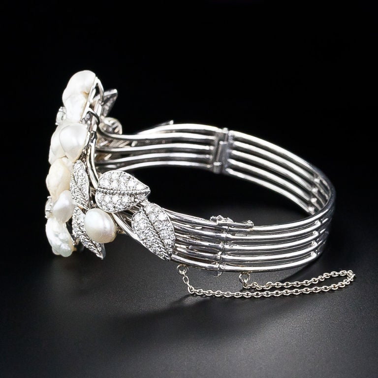 A magnificent, sparkling and highly distinctive bracelet in consummate Ruser style by, who else? Ruser of Beverly Hills. Shimmering freshwater pearl flowers are entwined with glittering platinum and diamond leaves in this unique work of jewelery