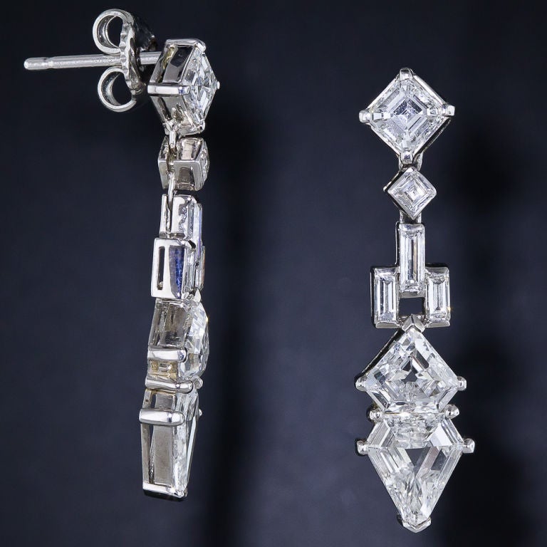 An interesting and artful array of high-quality, geometric shaped step-cut diamonds (square, baguette and shield) stack up to a total of just under 5.00 carats, and glisten together to create 1 and 1/4 inch long stunning platinum and diamond Art