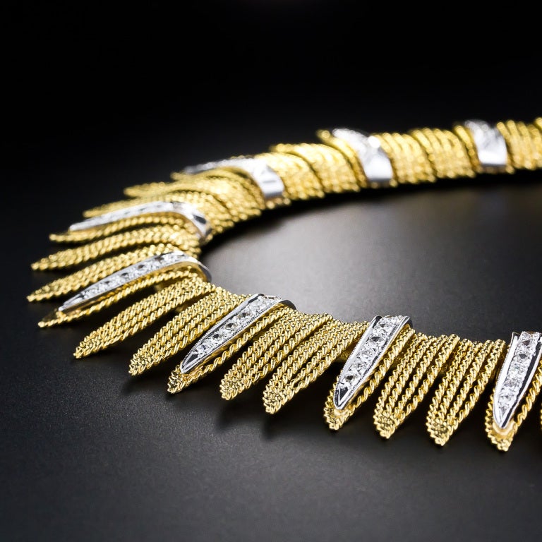 This classically styled flame motif fringe necklace from the 1960s is crafted in bright and weighty 14 karat yellow gold and sizzles with nine interspersed flames of round brilliant-cut diamonds set in contrasting white gold. This always stylish
