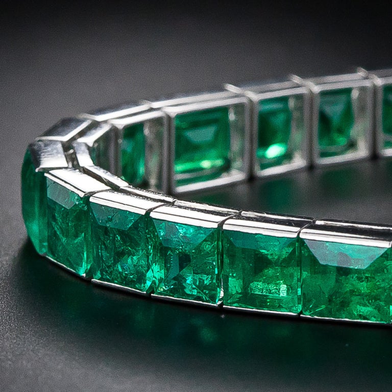 A breathtakingly beautiful platinum line bracelet glowing with thirty-two square and rectangular rich vivid green emerald-cut emeralds - totaling eighteen carats - the magnificent color of which is hard to improve upon. This rare and wonderful Art