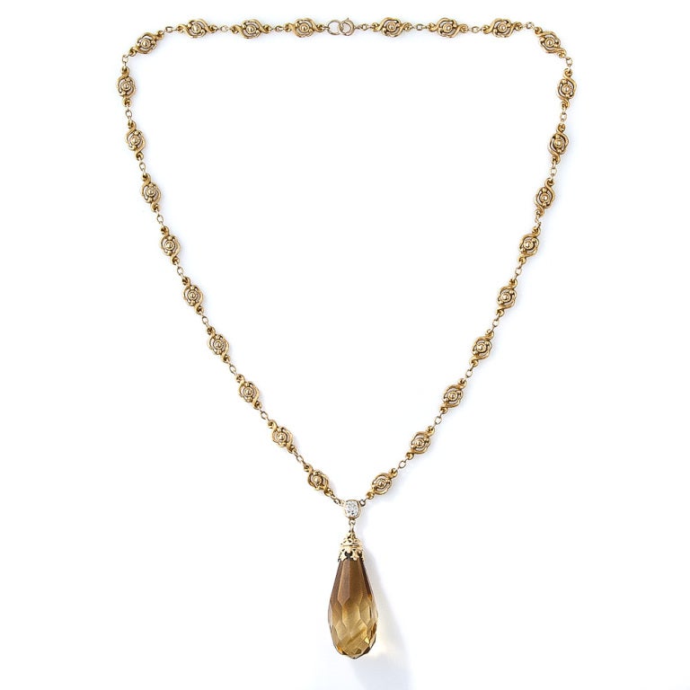 A 15 carat, three-dimensional briolette-cut citrine drops from this delightful, original Art Nouveau necklace produced during the earliest decades of the twentieth century. The golden citrine is topped with a fanciful yellow gold cap and suspended
