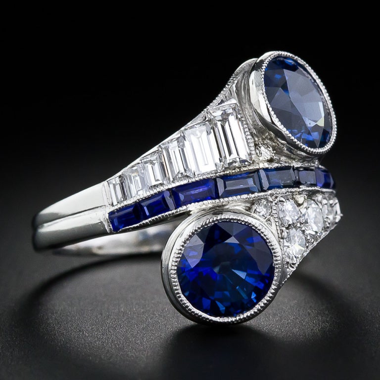Straight from the roaring twenties or thirties (with maybe a couple stops in between) comes this very cool and striking Art Deco sapphire and diamond dinner ring, hand crafted in platinum and featuring a pair of radiant, indigo-blue, round