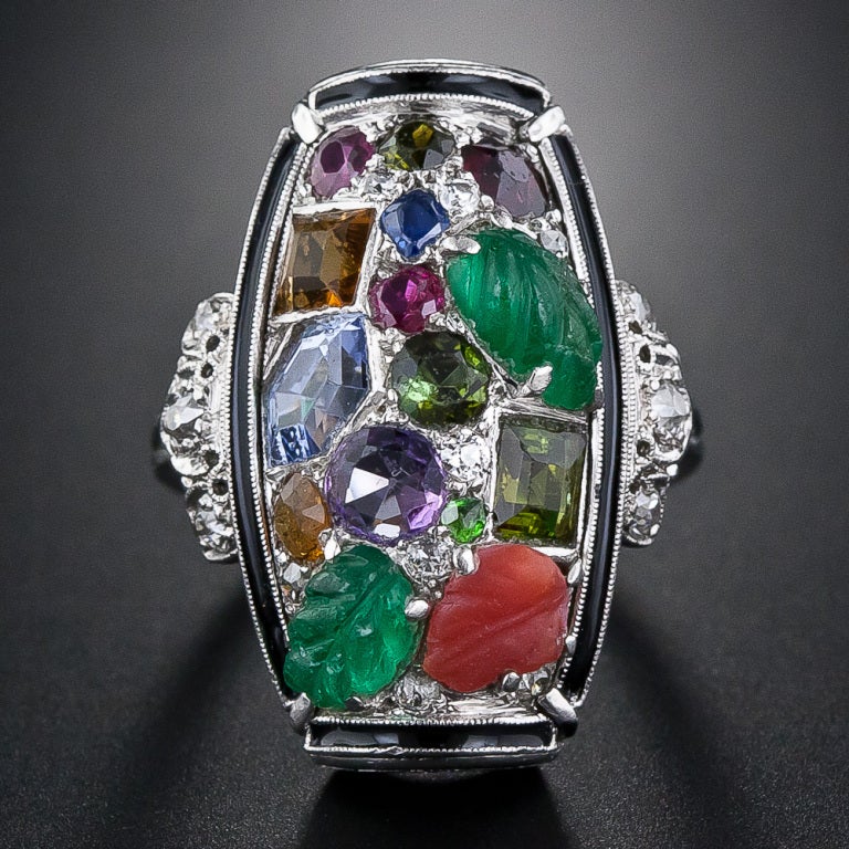 This singular and sensational work of wearable art was handcrafted in platinum during the high-Deco period - circa 1925. A colorful melange of gemstones, including: carved emerald, sapphire, ruby, amethyst, citrine and diamonds are artfully arrayed