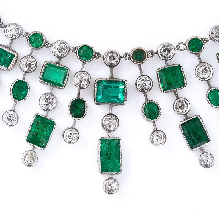 This unique, fun and festive fringe necklace glistens with a multitude of colorful Colombian emeralds and sparkling old mine-cut diamonds arrayed in no less than forty-nine separate fringes comprising the entire front (visible) portion of the