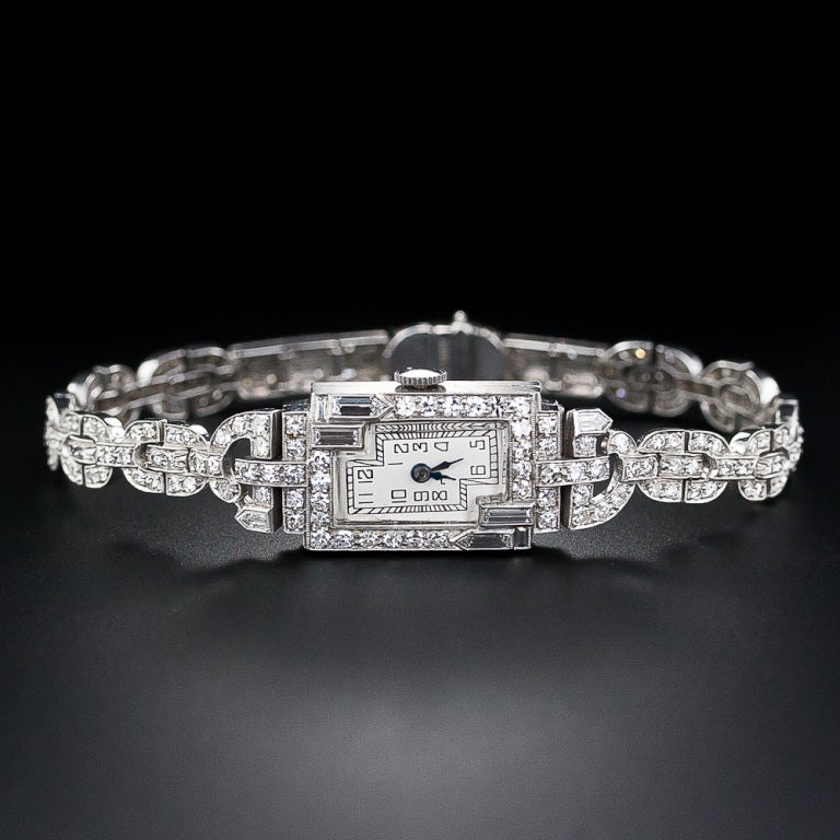 A magnificent and masterfully made Art Deco diamond bracelet watch with a sophisticated and geometric design. This fabulous and sparkling timepiece is presented inside an intriguing mirror-image frame incorporating bullet shape diamonds and baguette