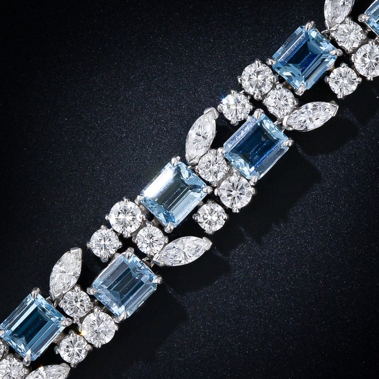 A truly gorgeous platinum, aquamarine and diamond bracelet, circa 1950s-1960s, by the great American jewelry manufacturer - Oscar Heyman. Eighteen deep pastel blue emerald-cut aquamarines (about as fine a color as they come in smallish sizes) are
