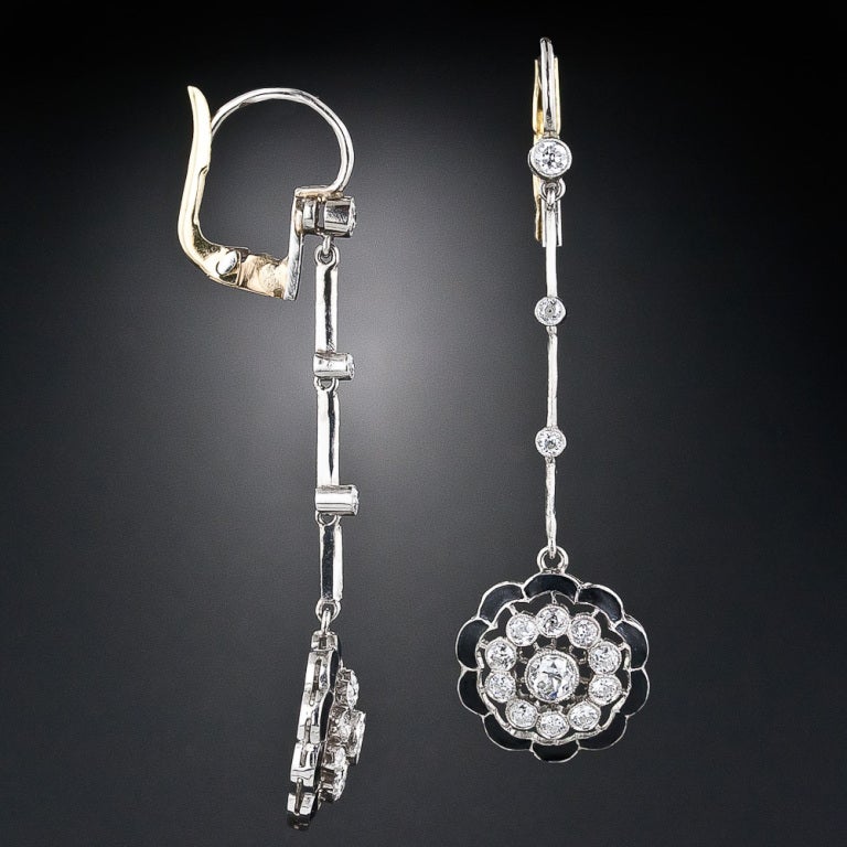 Wonderful and truly lovely early-Art Deco drop earrings. Each 1 and 1/8 inch-long eardrop sparkles with a rosette of European-cut diamonds which float from within a scalloped frame of matte black enamel. The drops dance from slender knife-edge