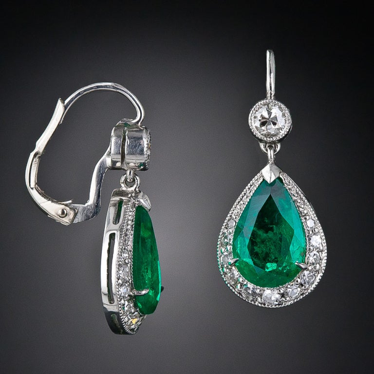 A beautifully matched pair of vibrant, bright-green pear-shape emeralds, weighing 3.50 carats total, are presented in classic style in these tasteful and timeless platinum and diamond eardrops, newly created to emulate their early-twentieth century