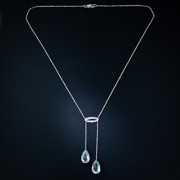 A truly exquisite Edwardian double aquamarine pendant, or negligee necklace, masterfully and delicately handcrafted in platinum around the turn-of-the-twentieth century. This fine and very feminine necklace glistens with a matched pair of pear-shape