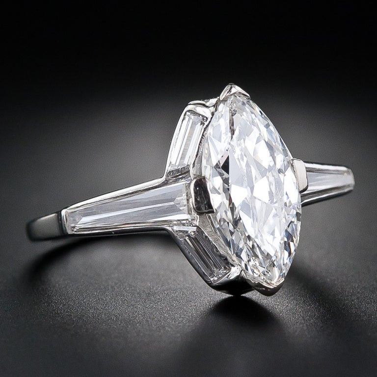 A gorgeous, bright-white and brilliant vintage marquise diamond, weighing 2.00 carats, dating back to the 1930s, is unusually and magnificently presented in a sleek and streamlined platinum and baguette diamond mounting. The graceful outline of the