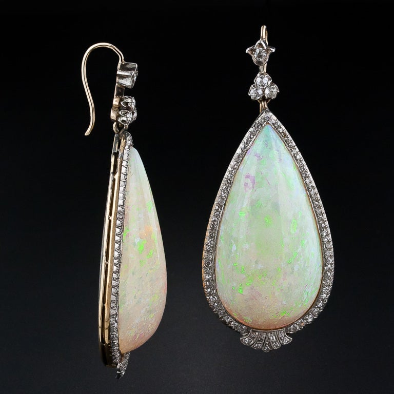 Incredible is the word to describe these enchanting and entrancing antique opal earrings of colossal proportions. A perfectly matched pair of pear shape drops, each weighing 45.00 carats - 90 carats total! - are delicately framed in platinum over 18