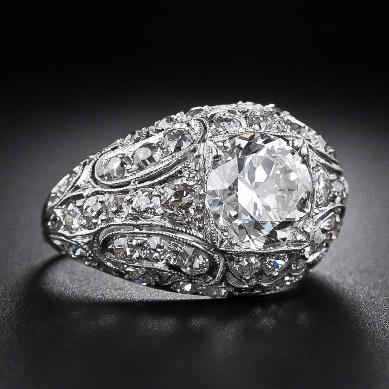 Wow! This breathtakingly beautiful late-Edwardian/early Art Deco dazzler features a gorgeous 2.43 carat European-cut diamond enveloped in a sparkling platinum and diamond dome. The magnificent bombe shaped ring sparkles on all sides with an