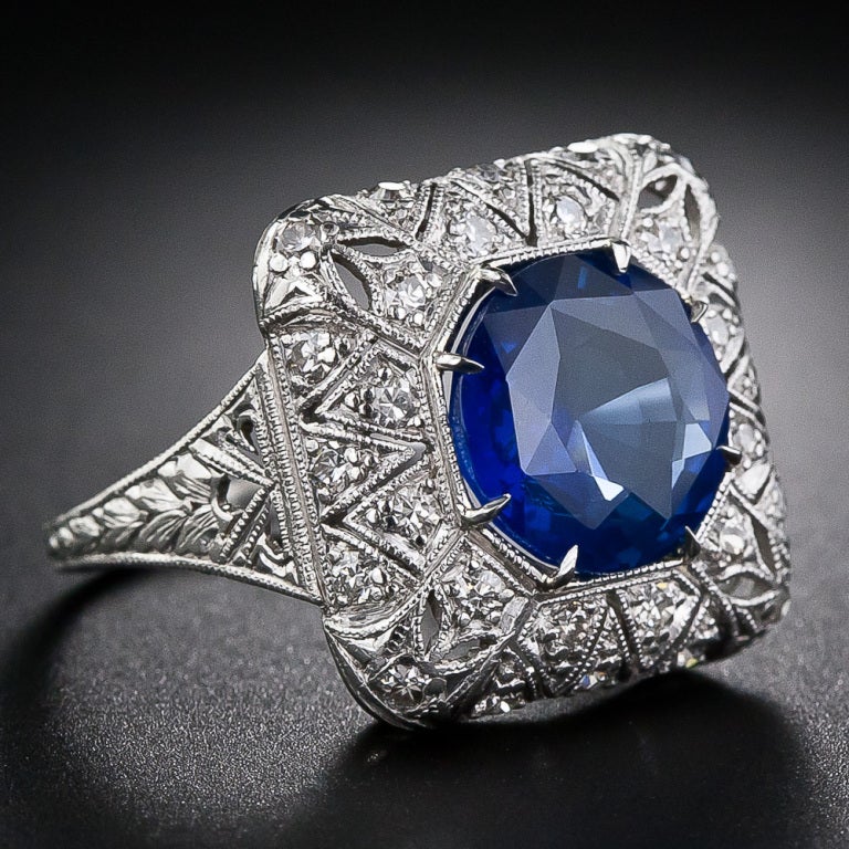 This striking, stunning and sizable early Art Deco sapphire and diamond ring highlights a bright and beautiful 4.50 carat royal blue Ceylon sapphire. The entrancing gemstone radiates from within a delicately milgrained octagonal setting enveloped in