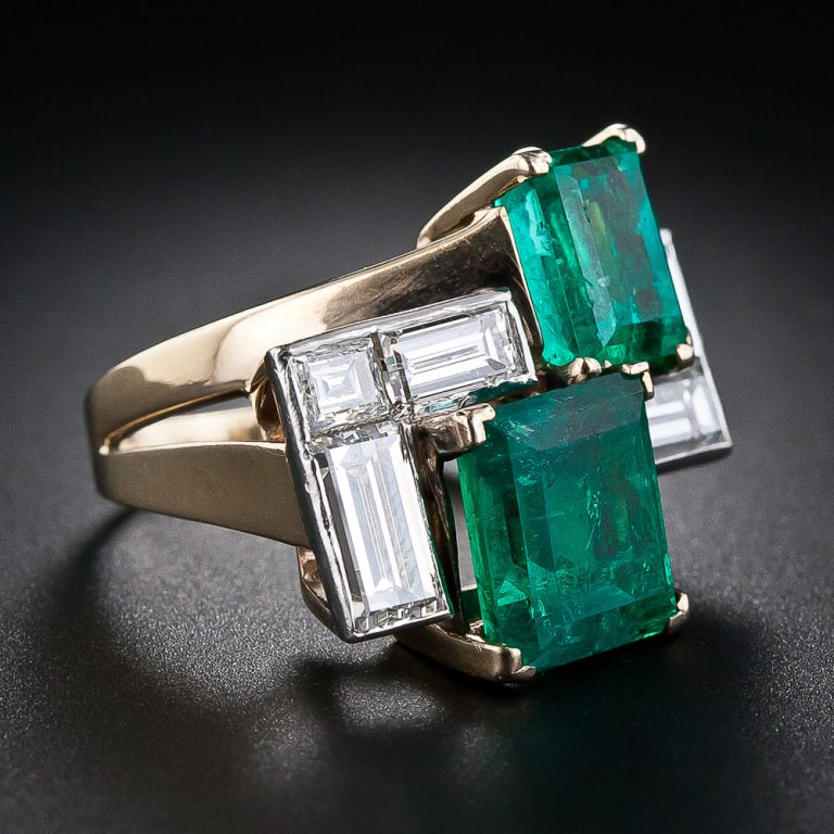 A bright and colorful example of mid-twentieth century wearable sculpture. An artful Mondrian-esque grouping of geometrical shapes rendered in a pair of vibrant green Columbian emeralds: 3.00 carats and 2.00 carats; and five bright-white baguette