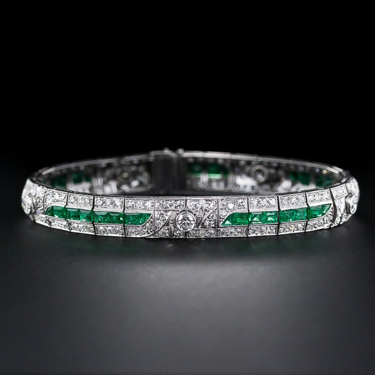 A gorgeous glistening line of rich, bright green emeralds is the main attraction of this exquisite and exemplary bracelet, finely crafted in platinum during the zenith of the Art Deco period - circa 1925. The beautiful line of emeralds is punctuated