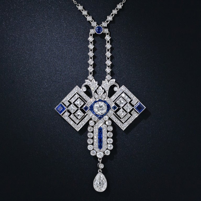 If you look closely, this fabulous Art Deco necklace can be construed as a highly-stylized geometric butterfly! The wings are comprised of six radiant and sizable French-cut diamonds accented with a pair of gemmy blue square sapphires. The head