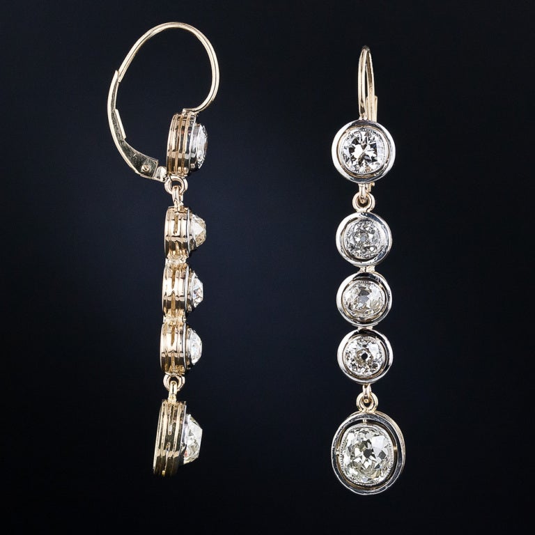Sparkling and sexy 1 and 1/2 inch long diamond earrings, crafted in platinum over 18 karat gold during the first one or two decades of the twentieth century. These early-Art Deco dazzlers dance to-and-fro with ten old mine-cut diamonds weighing 4.50